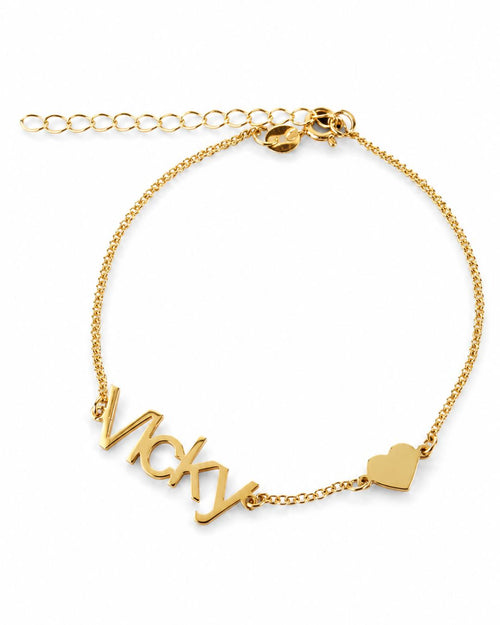 Gold-finish Fidji Love personalised bracelet with “Vicky” lettering, a small heart and an extension chain on a white background.