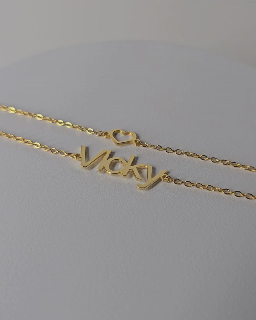 Video showing the gold-finish Hope personalised double chain bracelet with “Vicky” lettering and an open-heart detail.