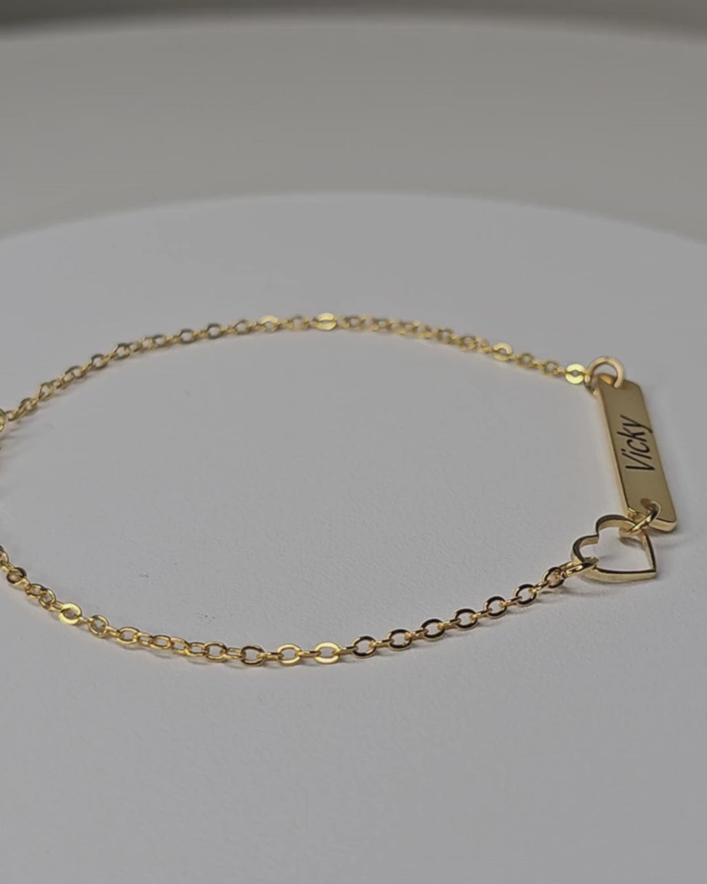 Video showing the gold-finish Venice Heart Bar Bracelet with an engraved rectangular bar, an open-heart detail and a fine chain.