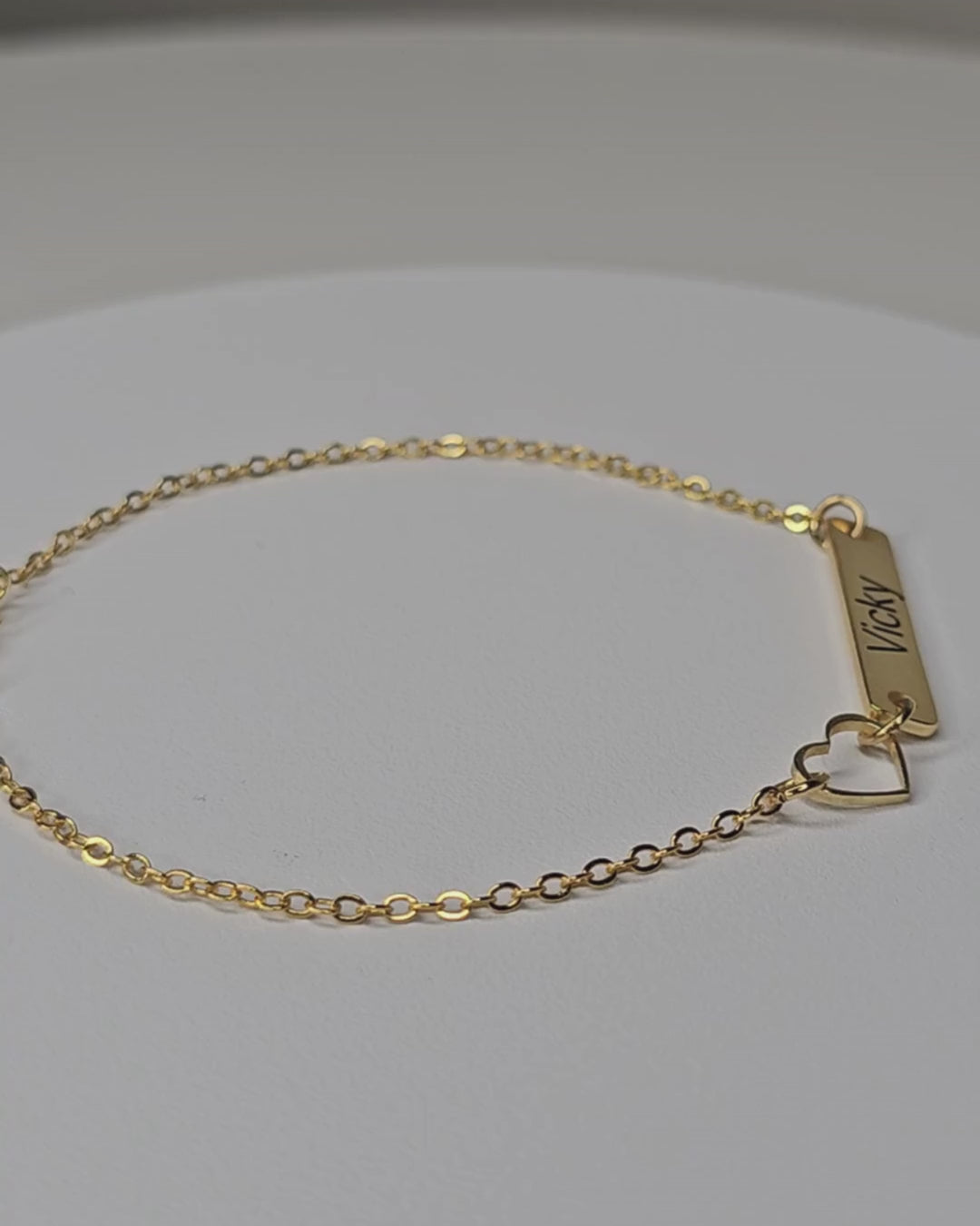 Video showing the gold-finish Venice Heart Bar Bracelet with an engraved rectangular bar, an open-heart detail and a fine chain.