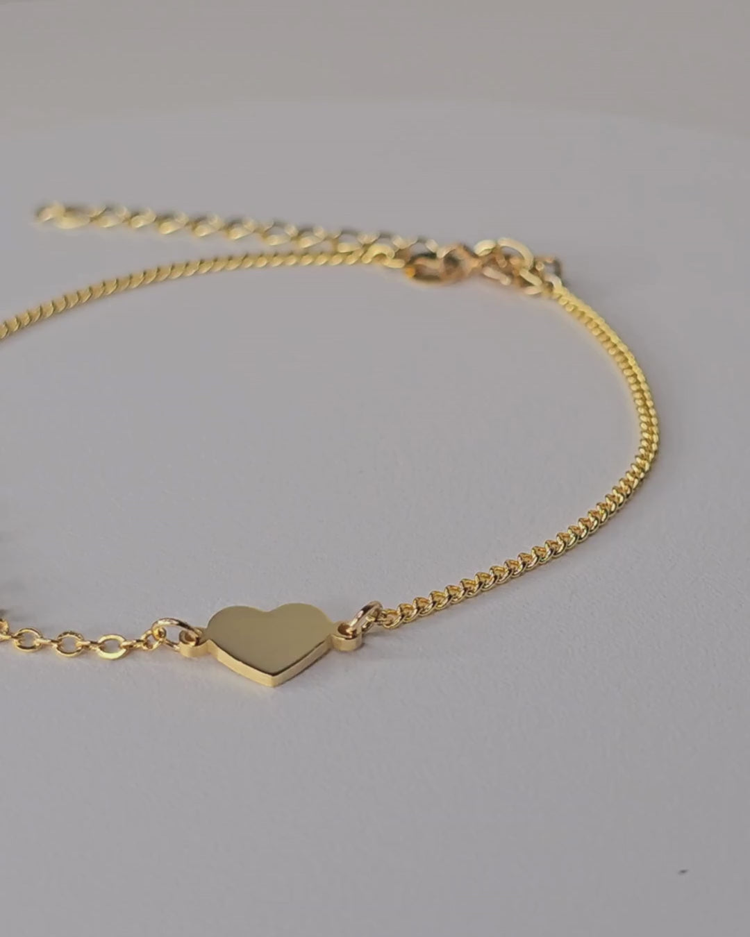 Video showing the gold-finish Fidji Love bracelet with personalised lettering, a small heart and a fine chain.