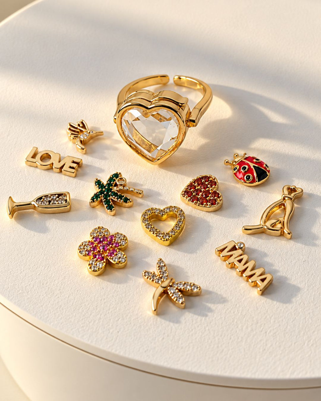 Bague Remember Ring dorée entourée de petits charms colorés pour personnaliser son cœur transparent.