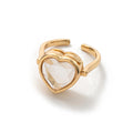 Bague Remember Ring dorée avec un cœur transparent facetté, présentée sur fond blanc.