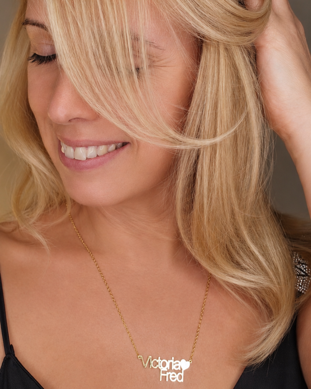 Woman wearing the Together personalised heart name necklace, featuring two lines of lettering and a heart detail.